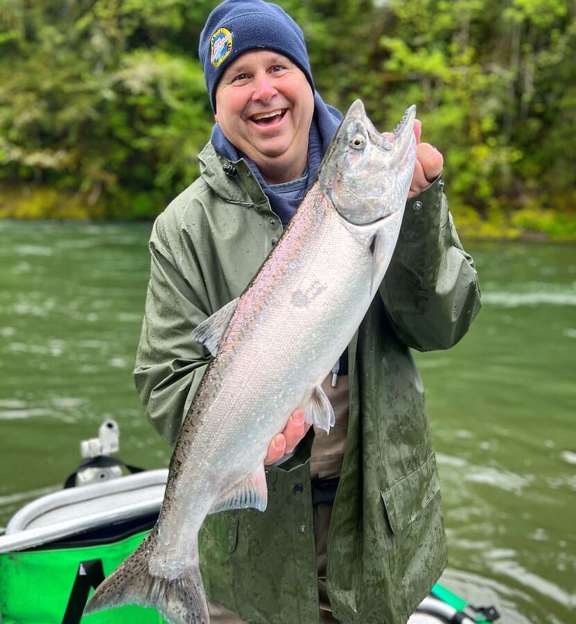 Smiling angler holding a steelhead